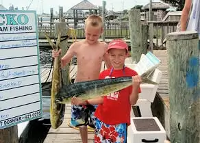 Two young anglers each holding mahi mahi.